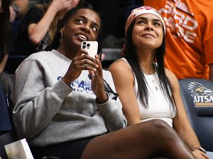 Jordyn Jenkins (left) and Nina De Leon Negron, both members of last season's UTSA women's basketball team, watch as the 2024-25 American Conference championship banner is unfurled on Thursday at the Convocation Center. - Photo by Joe Alexander